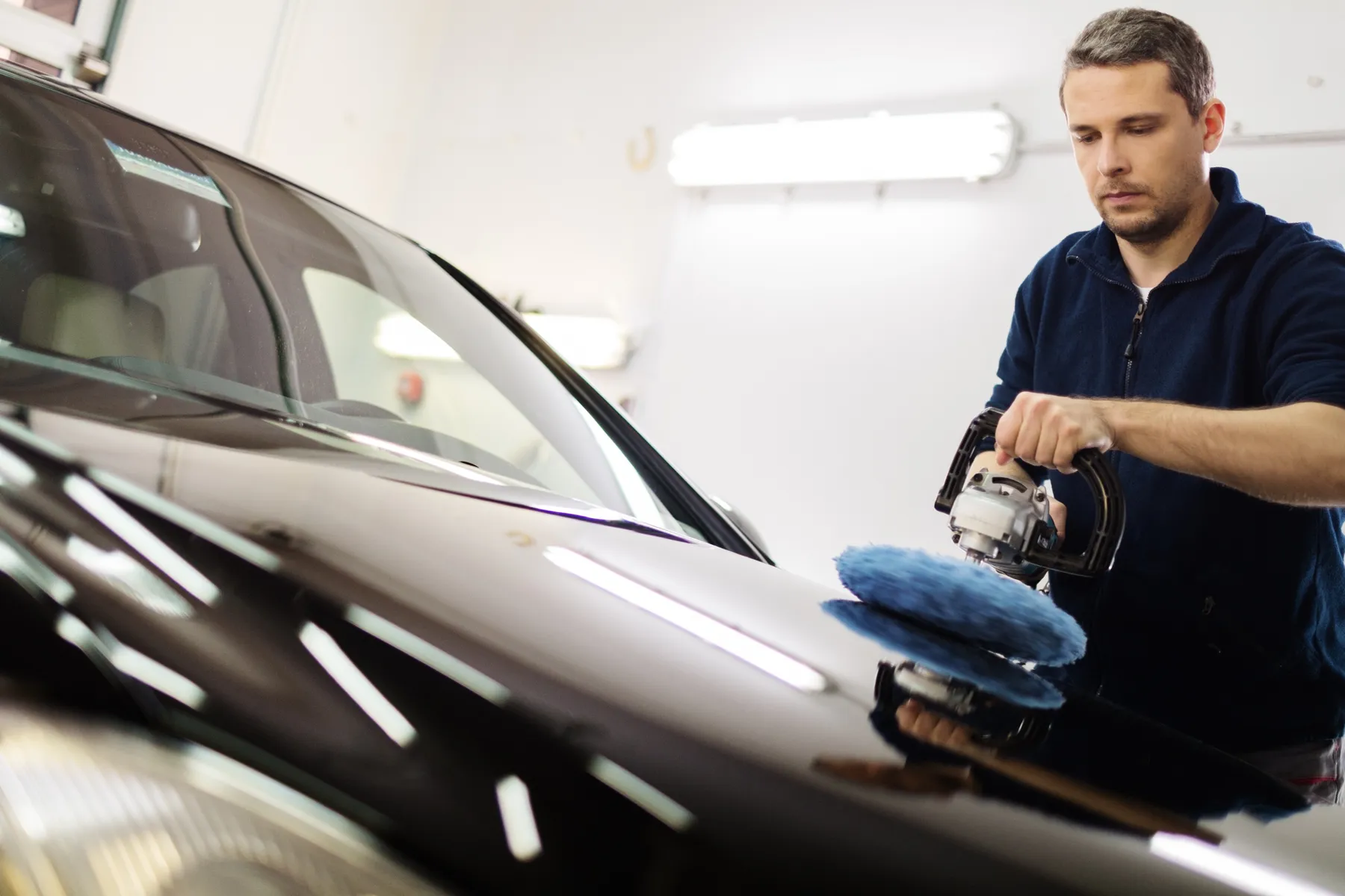 Detailer machine polishing a car