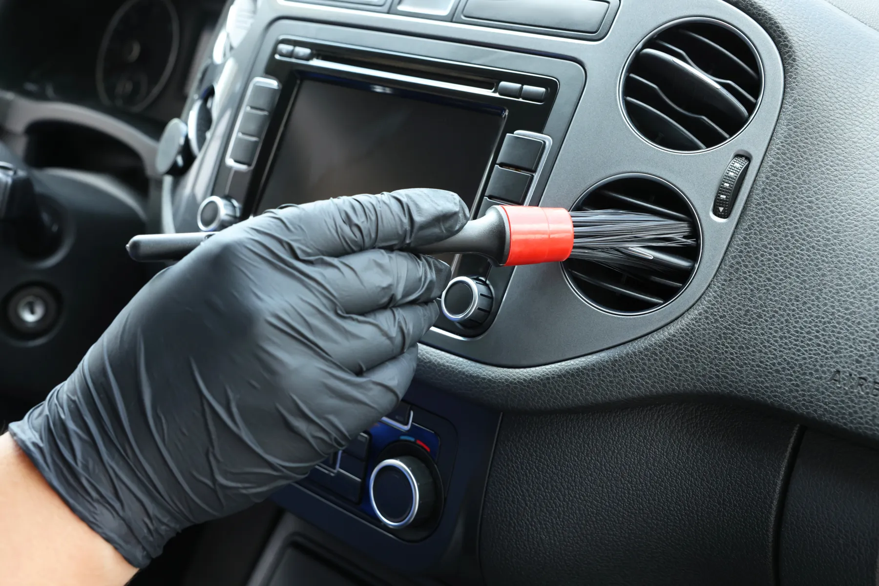 Brushing dust out of dashboard air vents