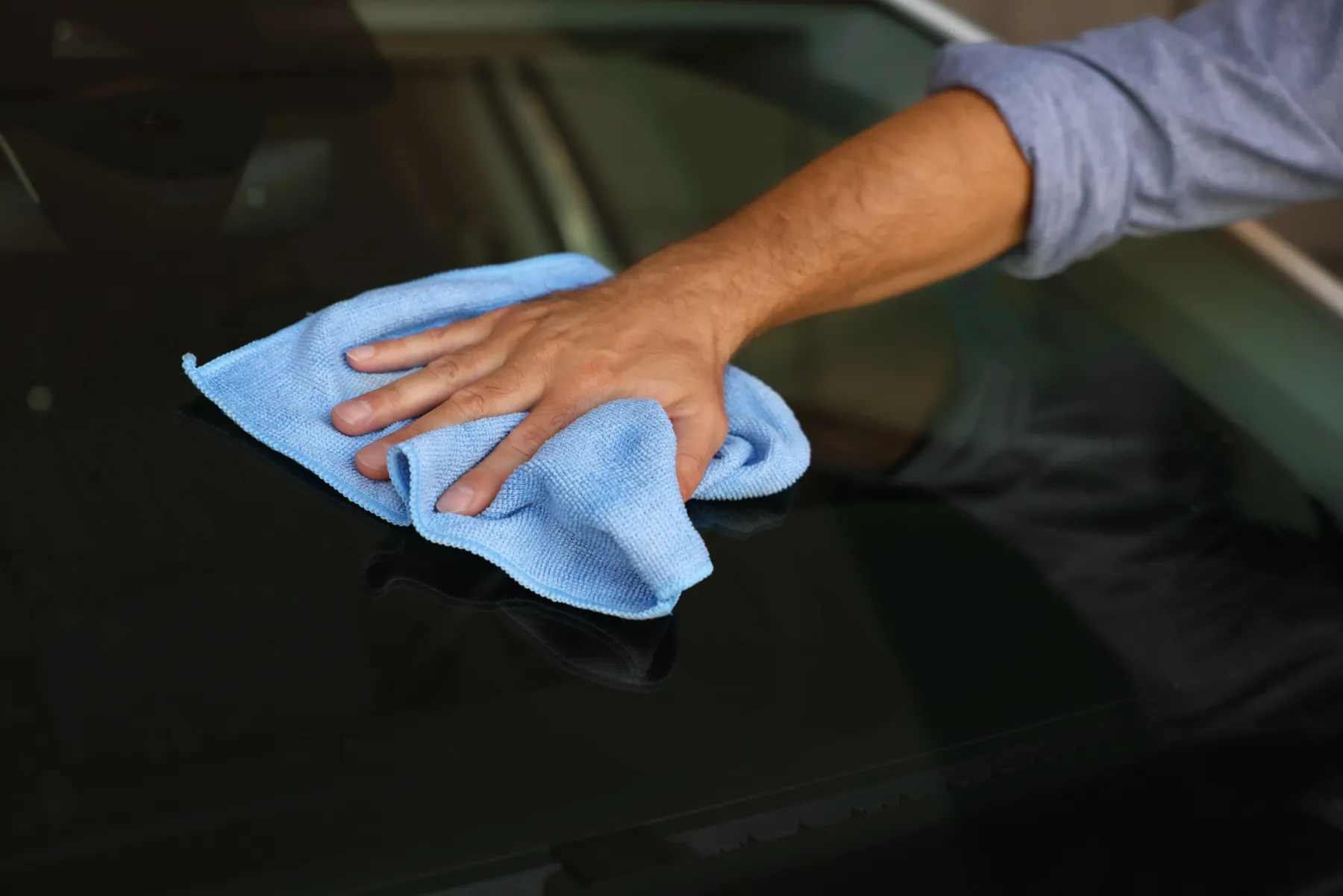 Wiping a windshield with a microfiber towel